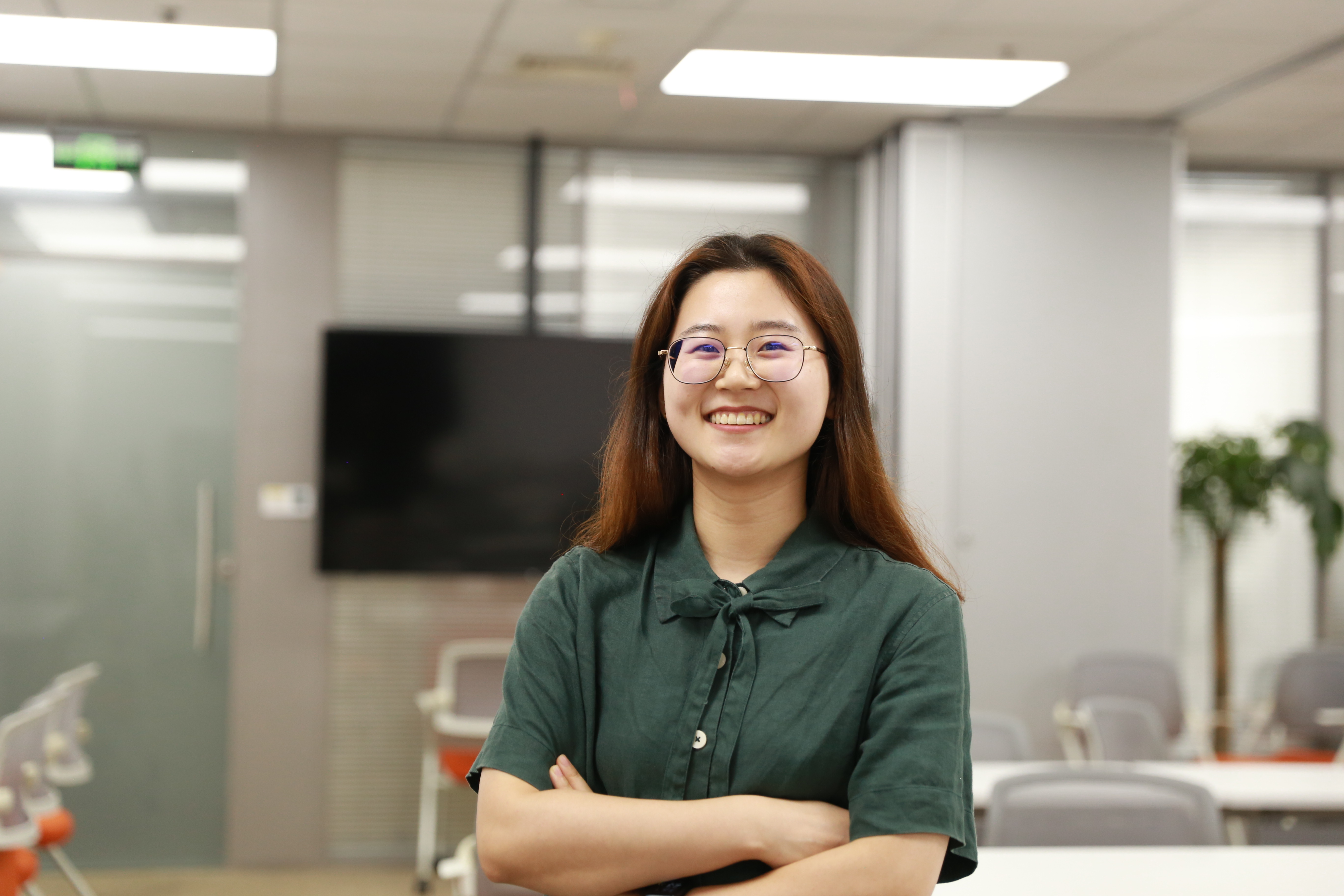 a person smiling with arms crossed