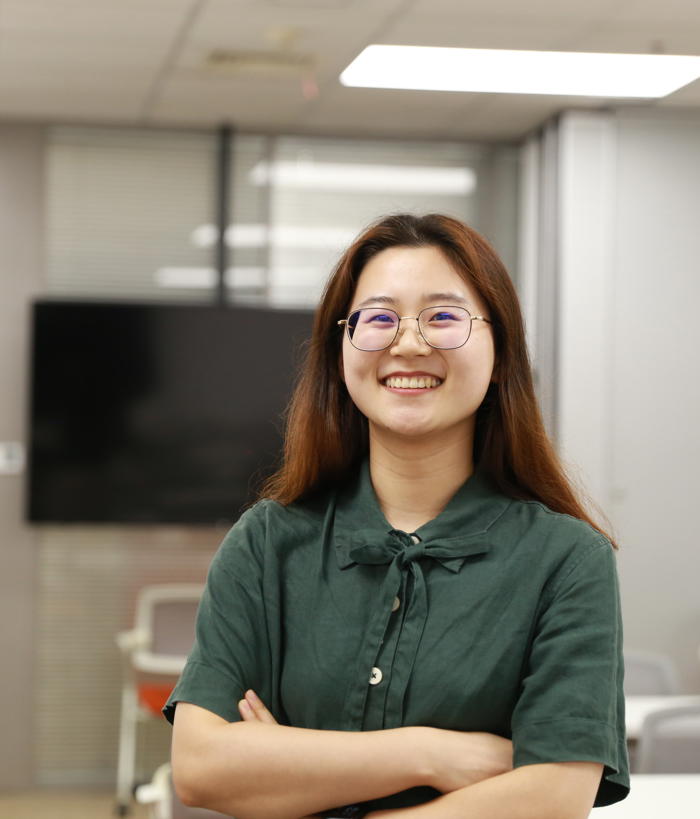 a person smiling with arms crossed