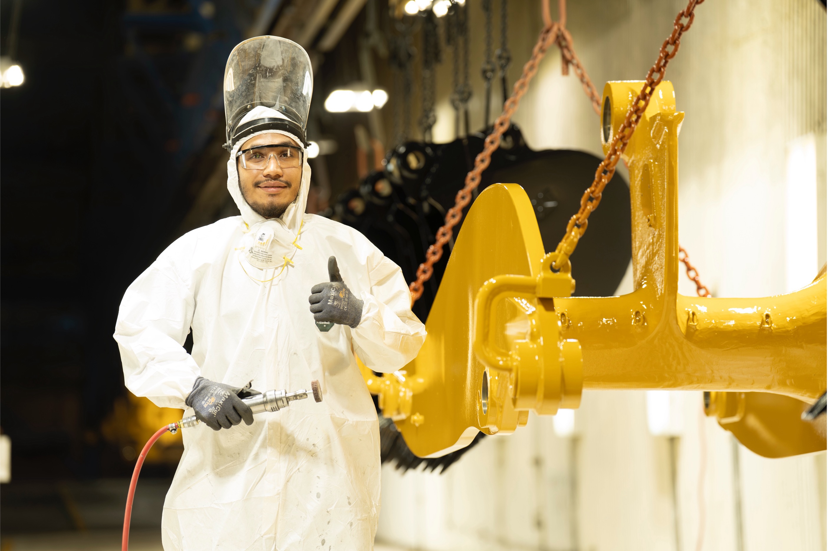 a person in a white suit holding a tool