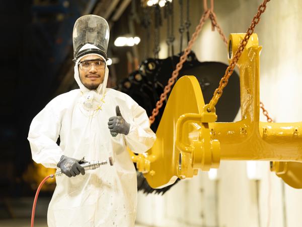a person in a white suit holding a tool