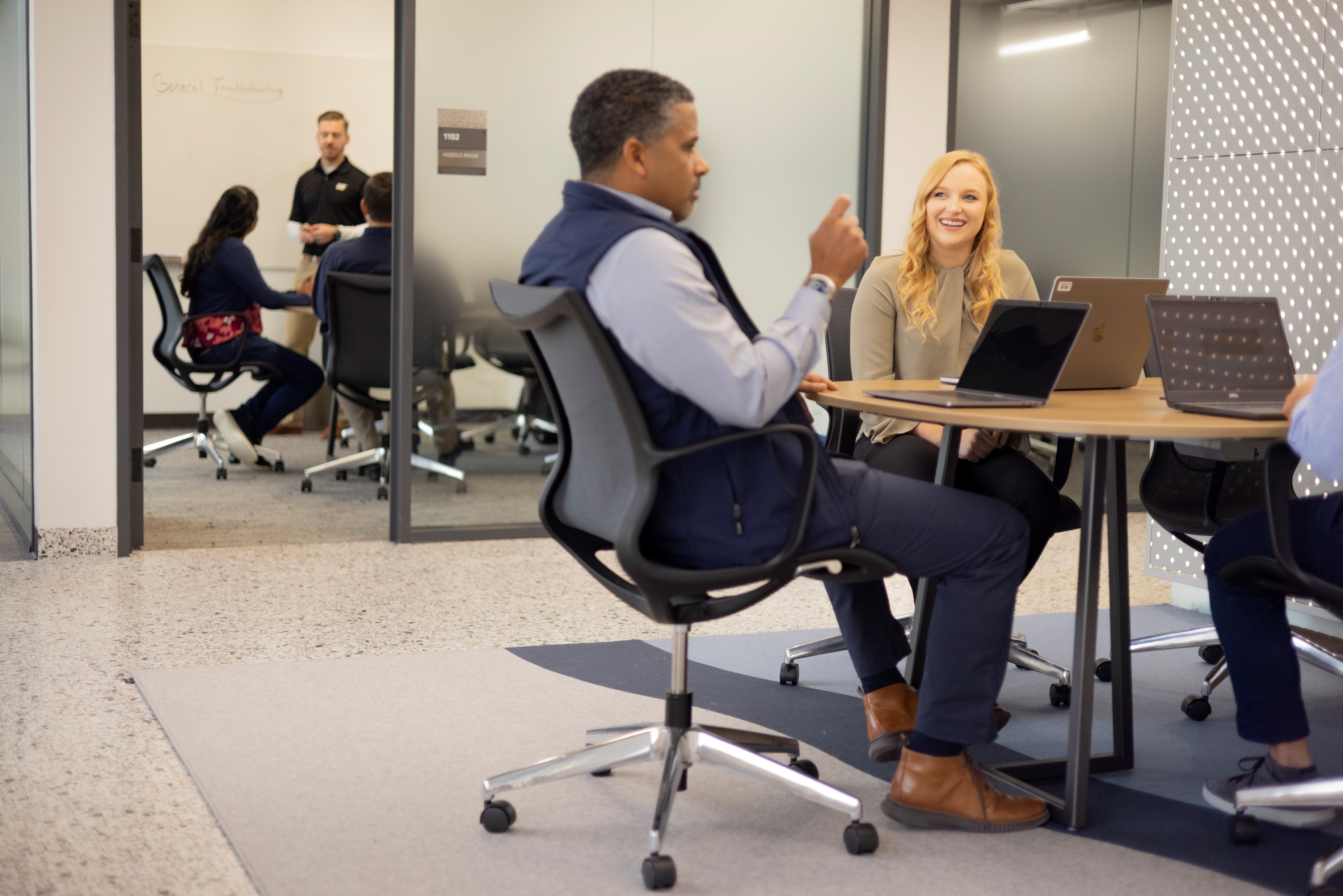a person and person sitting at a table with laptops