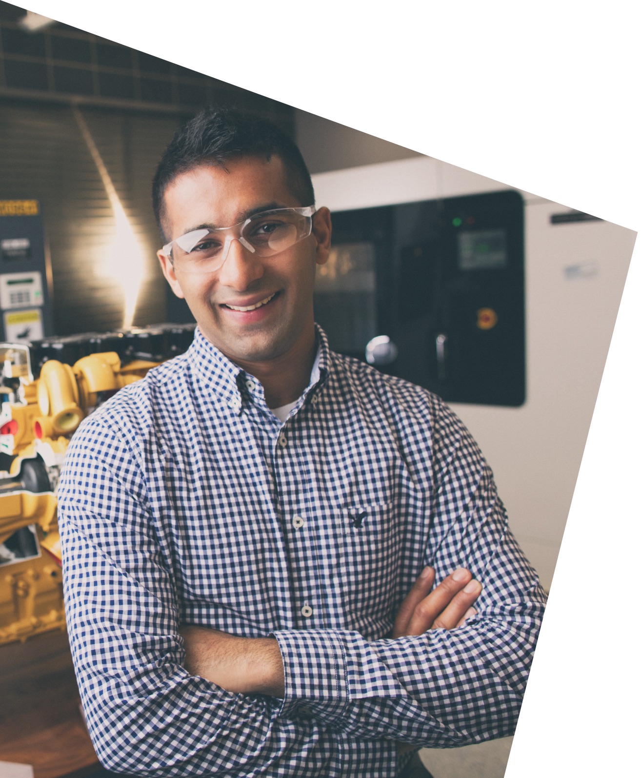 a person wearing safety glasses and standing with his arms crossed