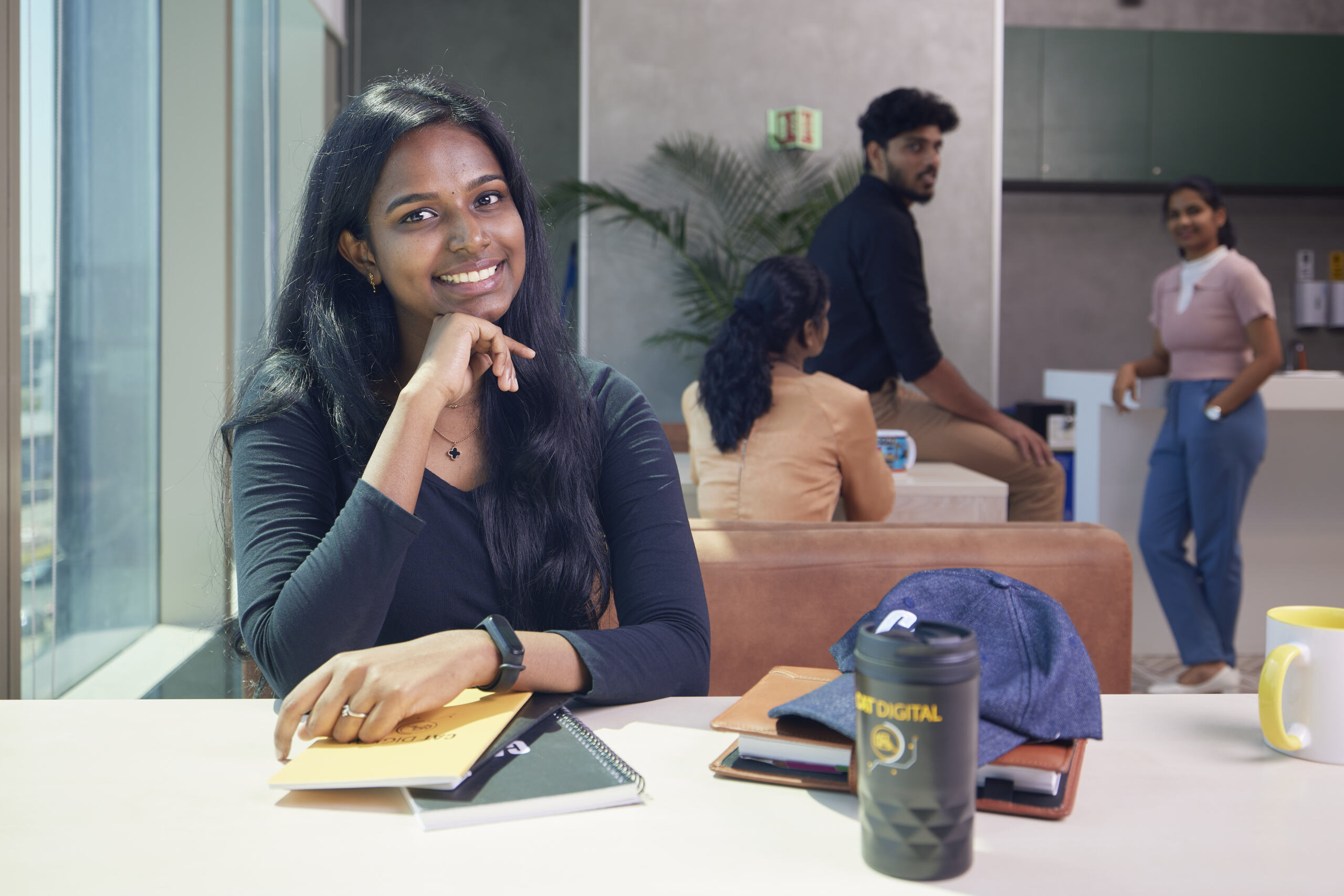 a person sitting at a table with her hand on her chin