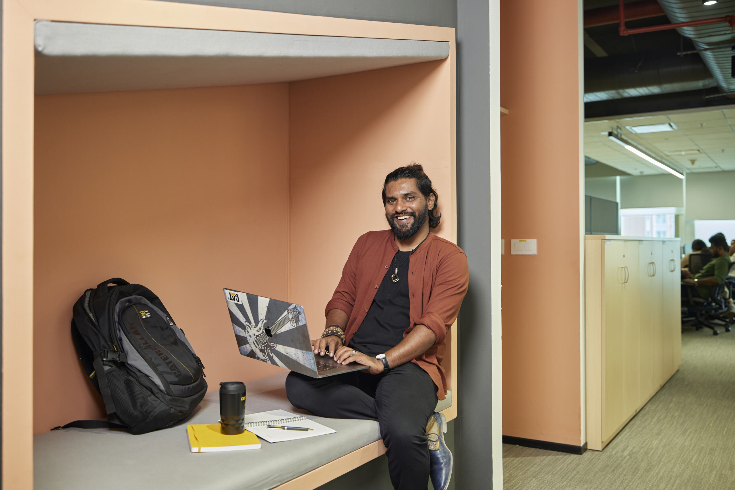 a person sitting on a bed using a laptop