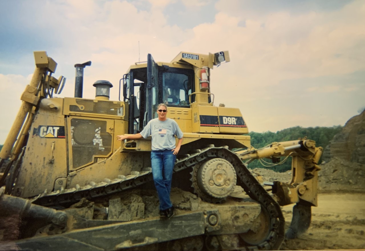 a person standing on a large yellow tractor