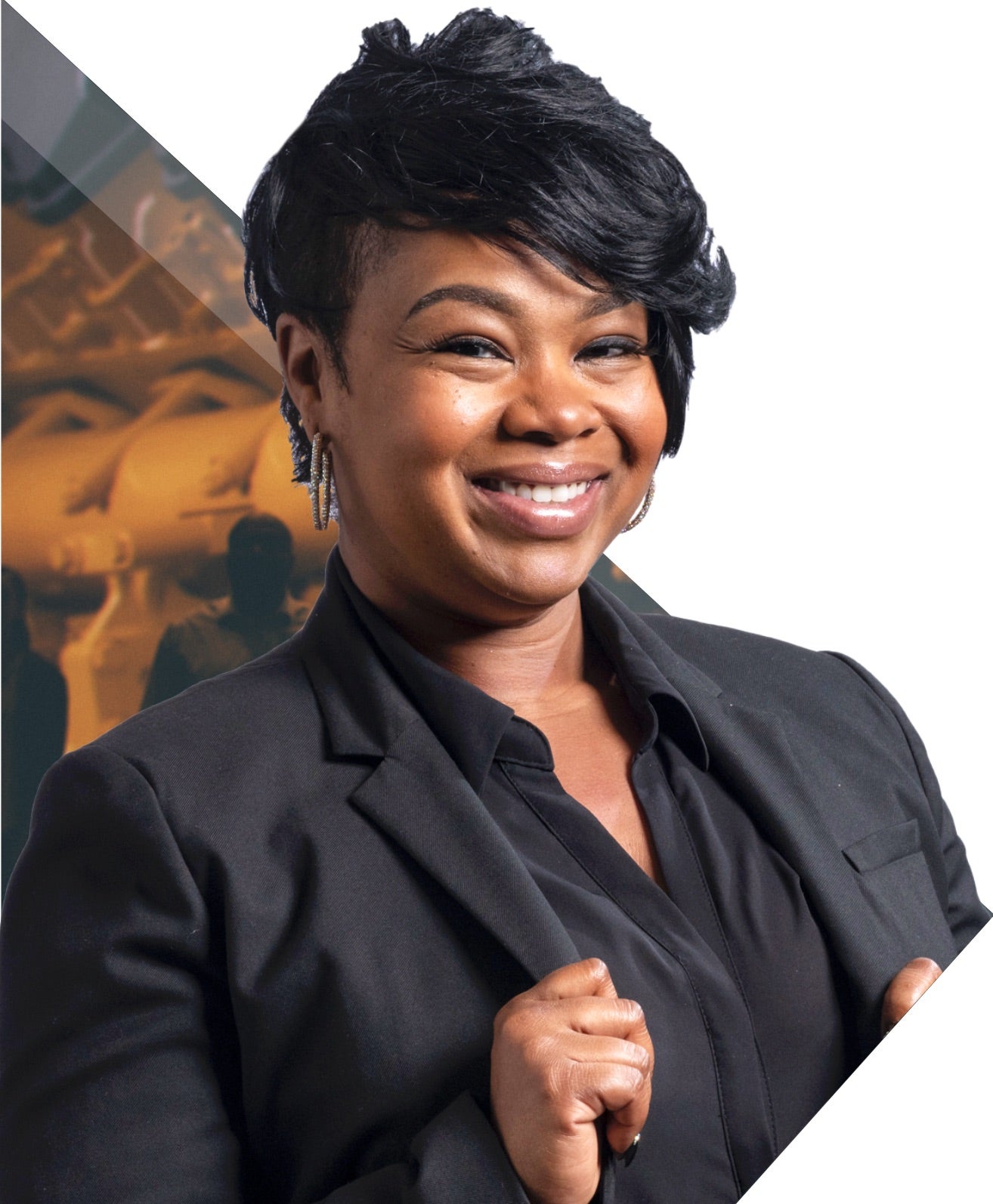 a person smiling with short hair wearing a black suit