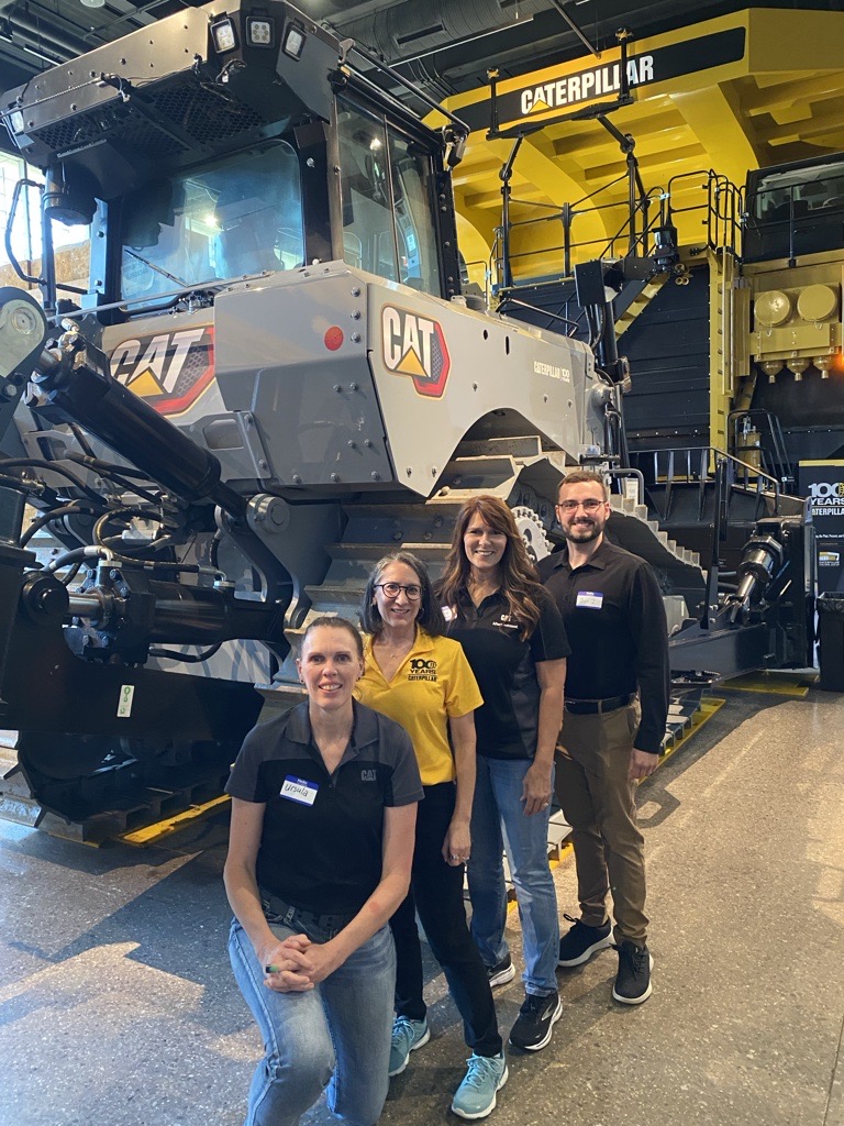 a group of people standing in front of a large vehicle