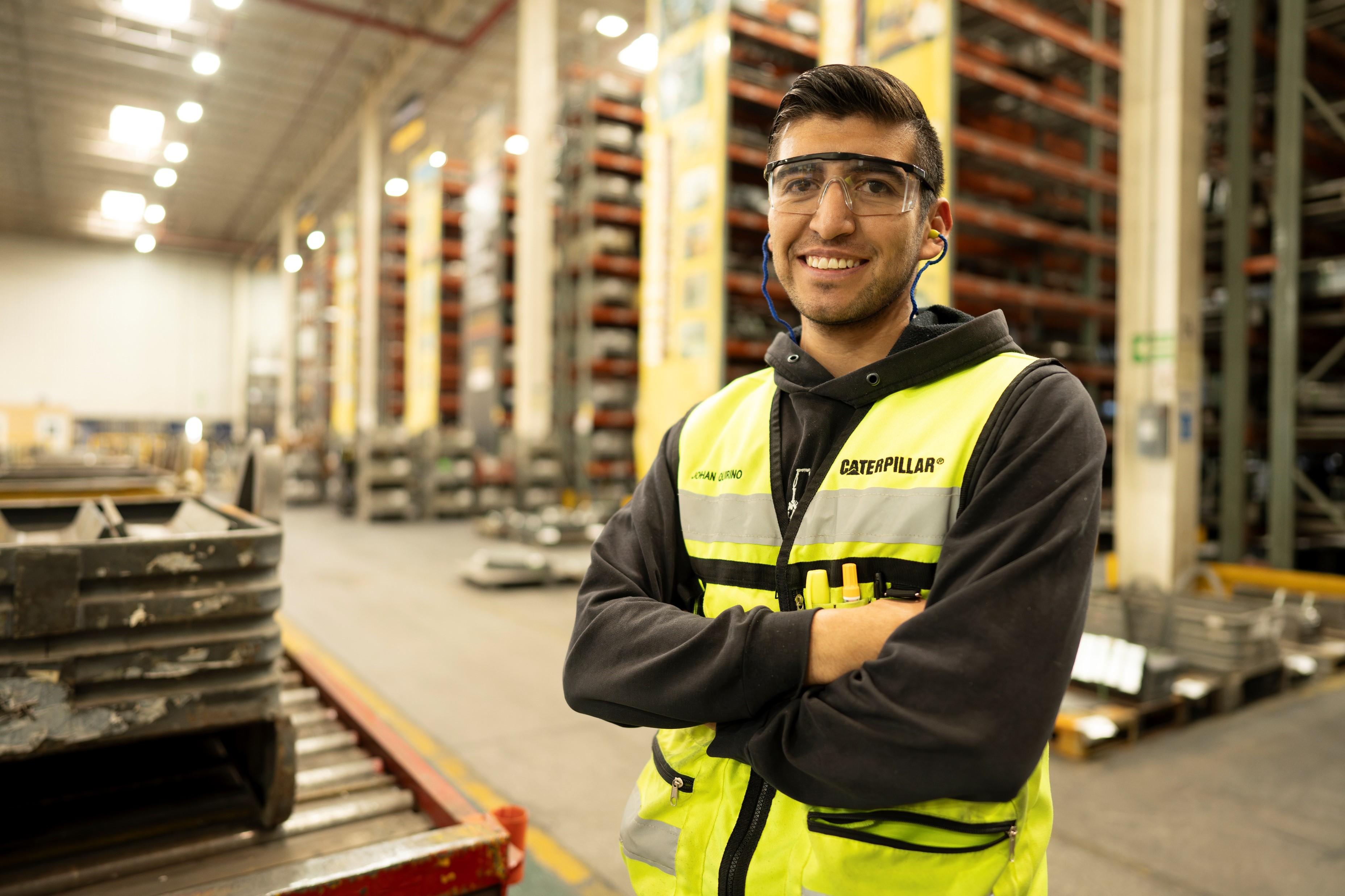 a person wearing safety goggles and a yellow vest