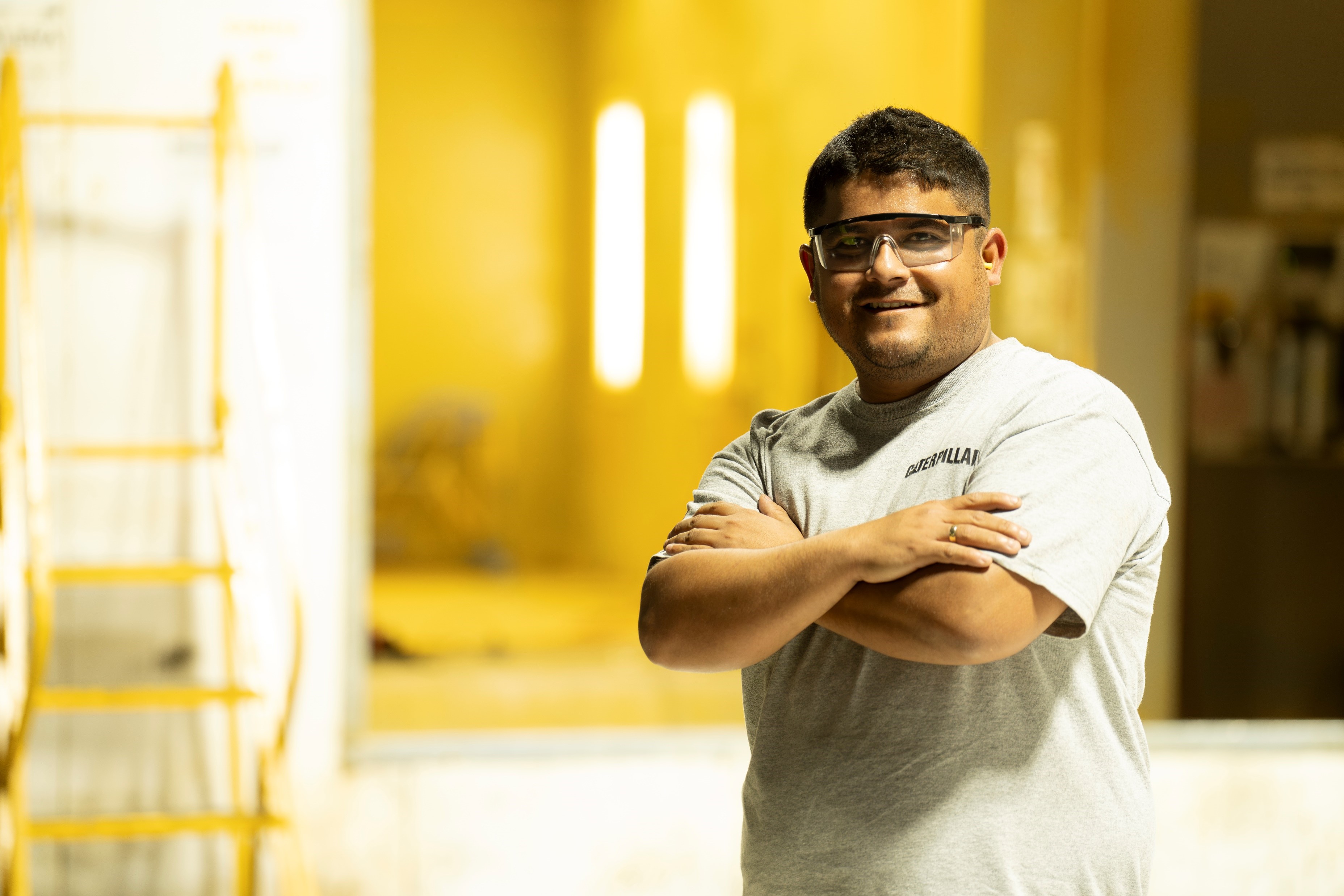 a person with glasses and a grey shirt with his arms crossed
