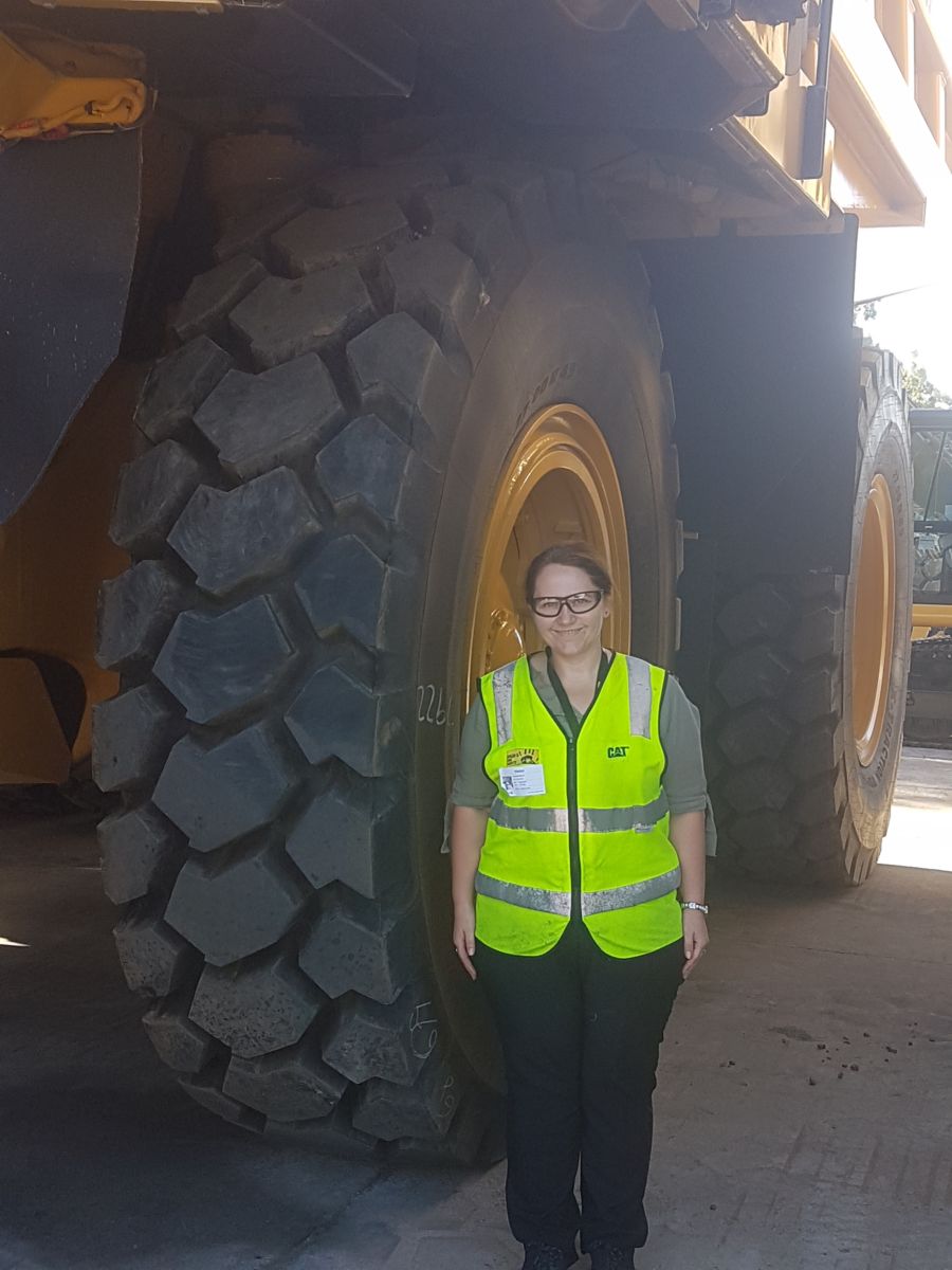 a person standing in front of a large tire