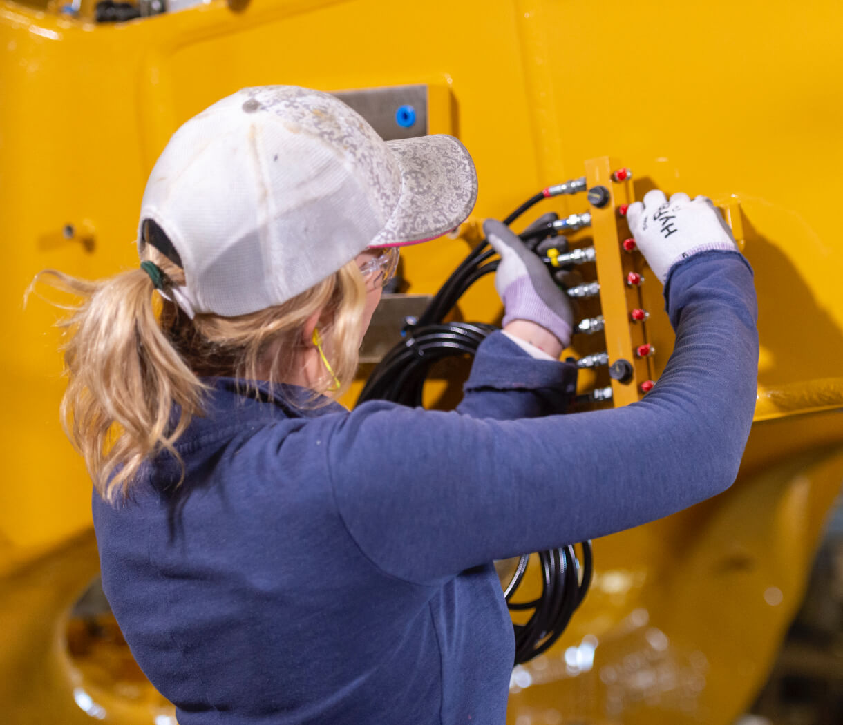 a person in a white hat working on a machine